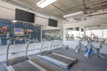 A gym with treadmills, exercise bikes, and other equipment